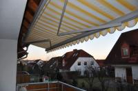 Markise mit gelb/weiß-gestreiftem Stoff 